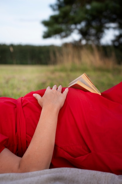 Free photo side view pregnant woman spending time outdoors