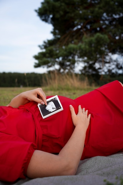 Free photo side view pregnant woman spending time outdoors