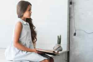 Free photo side view of pretty girl reading book