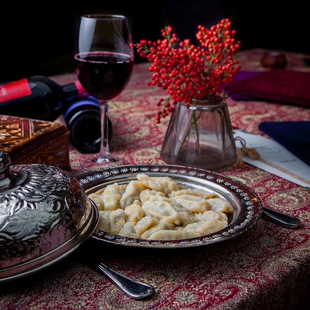 마가 목 열매와 구리 접시에 레드 와인 측면보기 qurza