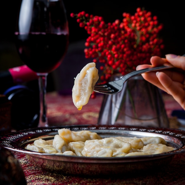 Foto gratuita vista laterale qurza con frutti di sorbo e vino rosso e mano umana e forcella in lamiera di rame