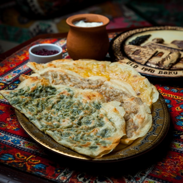 Side view qutab assorted with sumac and yogurt in tray