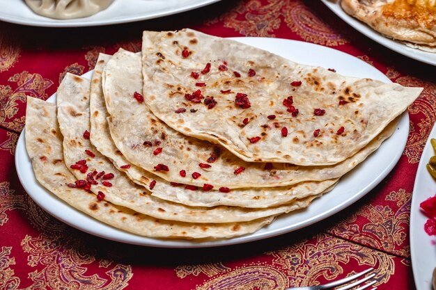 Side view qutab with ground meat and dried barberry on a plate