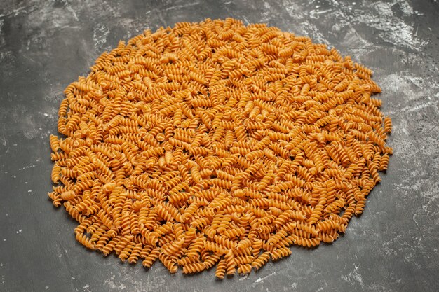 Side view of raw Italian pasta lined up in a circle on gray background