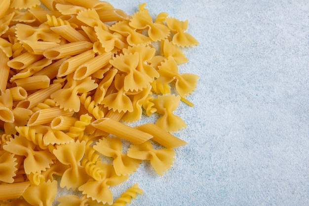 Vista laterale della pasta cruda su una superficie grigia