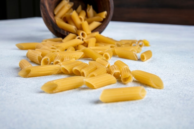 Side view of raw pasta in an inverted bowl on a gray surface