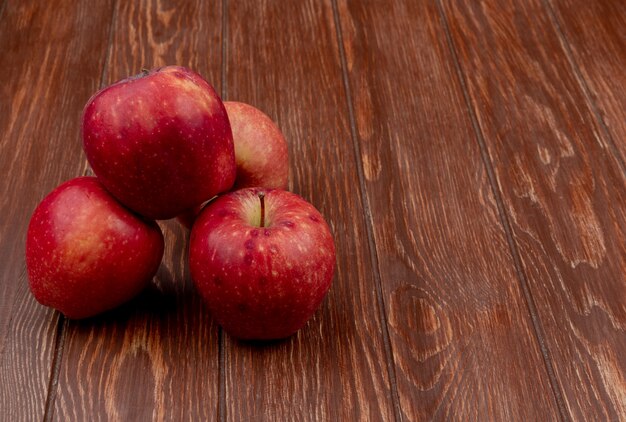 コピースペースを持つ木製の背景に赤いリンゴの側面図