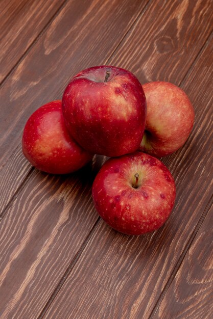 Вид сбоку красных яблок на деревянной поверхности