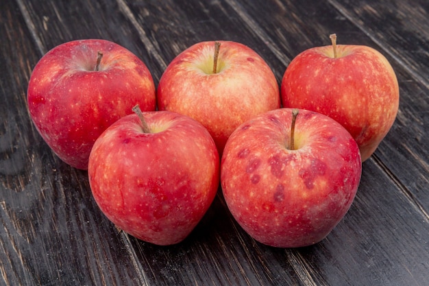 side view of red apples on wooden