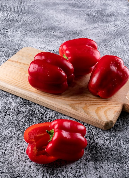 Side view red bell pepper on wooden cutting board