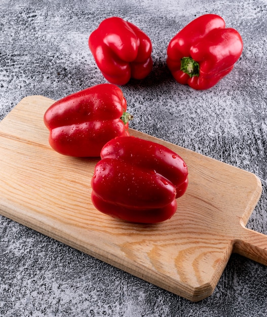 Side view red bell pepper on wooden cutting board