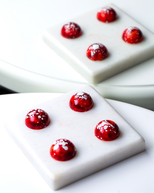 ミラーイメージの白いスタンドに白い斑点のあるチョコレート菓子で赤い側面図