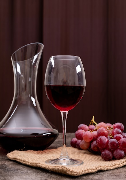 Side view red wine in glass with grape on vertical