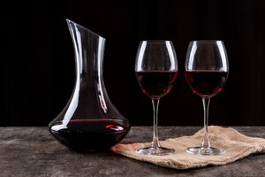 Free photo side view red wine in glasses and linen cloth on dark horizontal