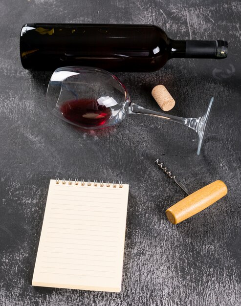 垂直の黒い石のノートにコピースペースを持つ側面図赤ワイン
