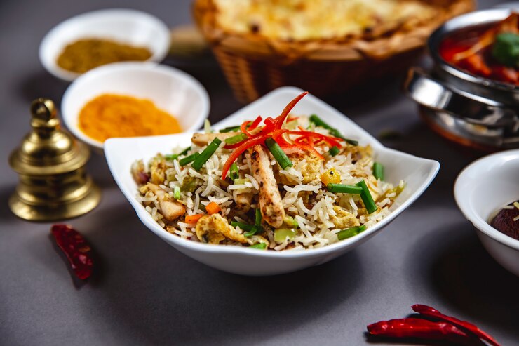 Free Photo side view rice garnish with grilled chicken cucumber carrot bell pepper and spring onion