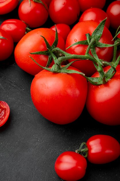 Side view of ripe fresh tomatoes on black background