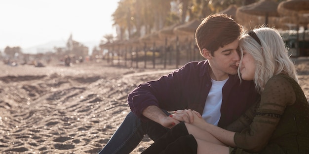 Free photo side view of romantic couple on the beach