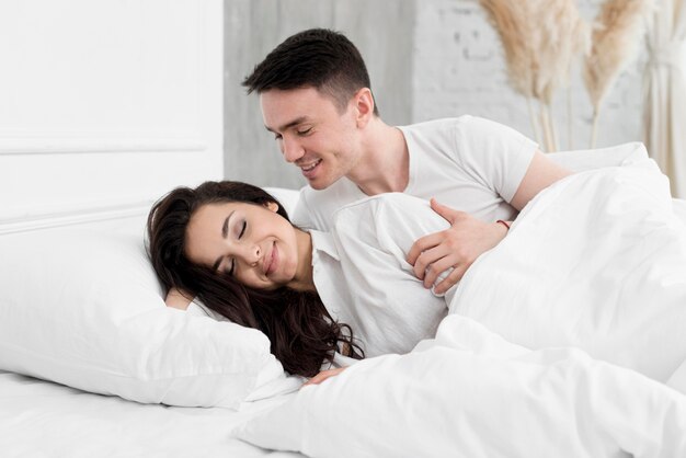 Side view of romantic couple in bed at home