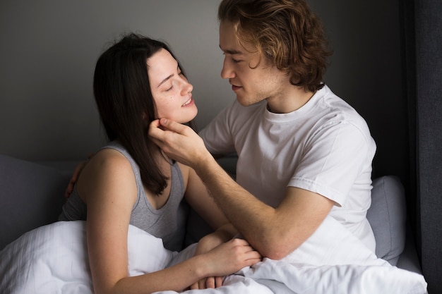 Вид сбоку романтичной пары в постели