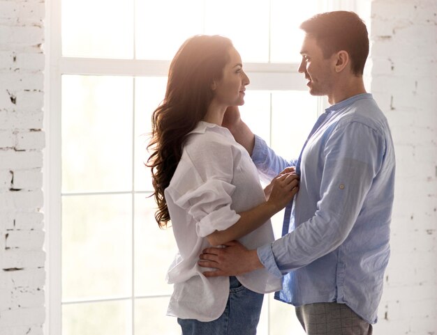 Side view of romantic couple by the window