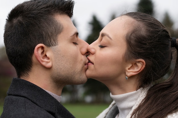 Free photo side view romantic couple kissing