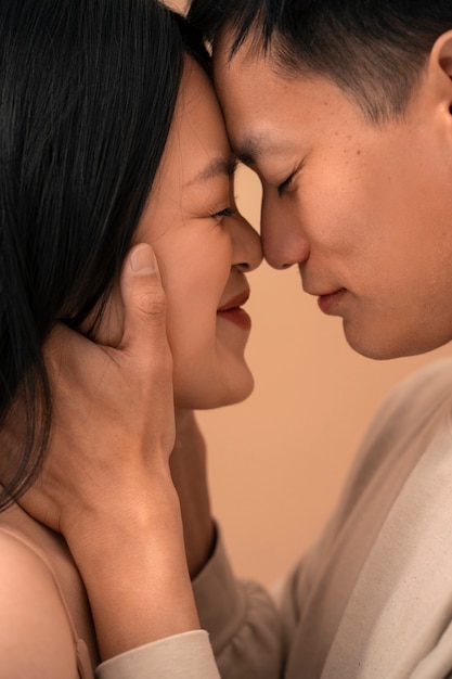 Free photo side view romantic couple posing in studio