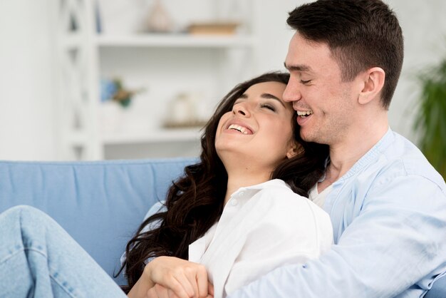 Side view of romantic couple on sofa at home