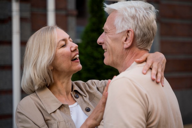 Free photo side view of romantic elder couple embraced while out in the city