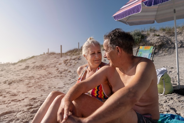 Foto gratuita anziani romantici di vista laterale alla spiaggia