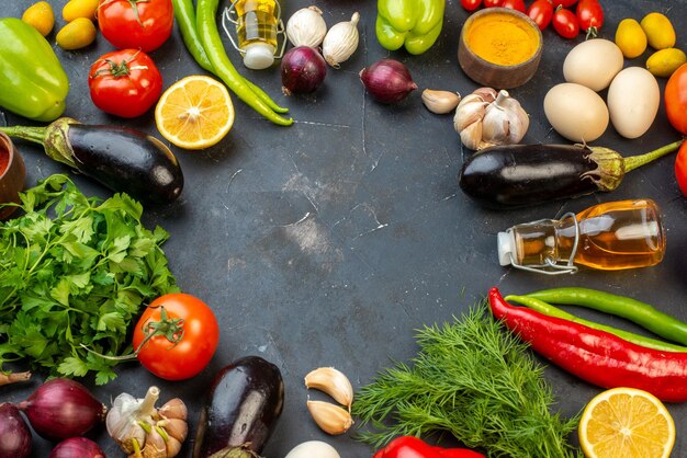 Side view of round shaped free space fresh vegetables fallen oil bottle eggs lemons spices on black background