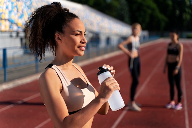 Side view runner holding a bottle of water