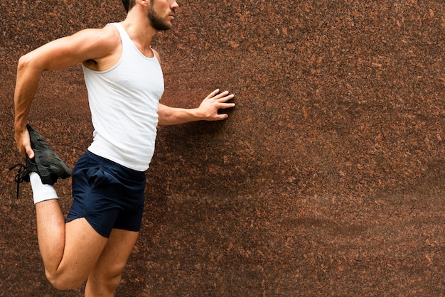 Free photo side view of runner stretching