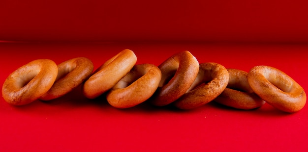 Free photo side view of russian bagels on red background