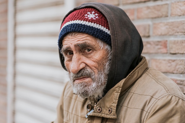 Side view of sad bearded homeless man