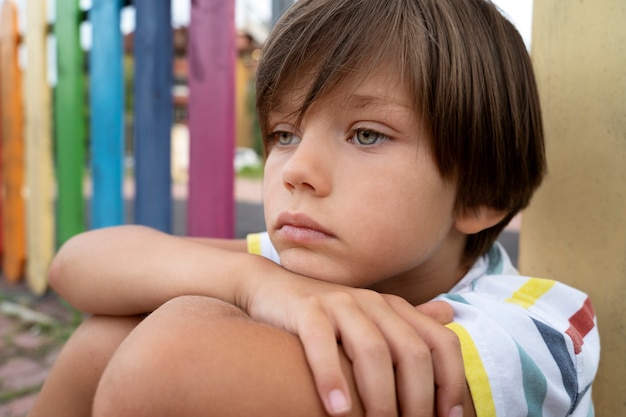 Free photo side view sad boy in park