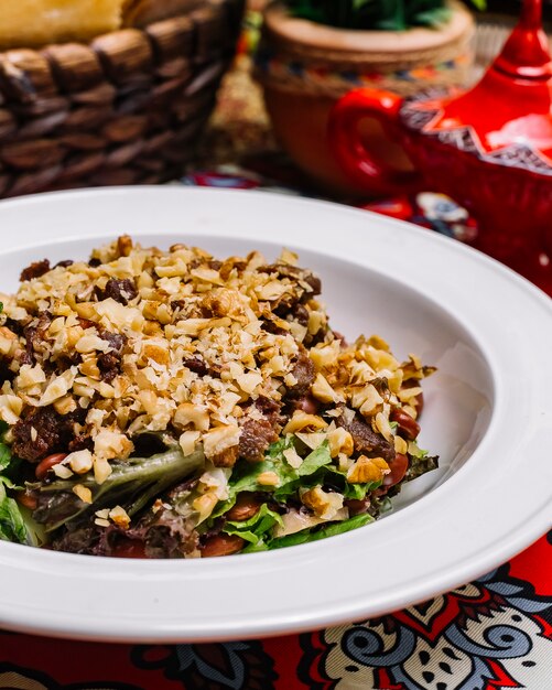 Side view salad with walnuts and meat