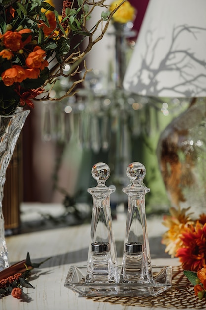 Side view of salt and pepper glass shaker with metal cap on the table