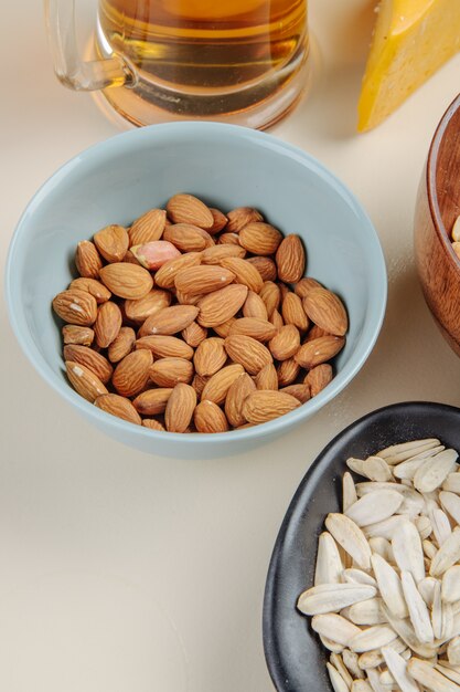 Side view of salted nuts to beer on white