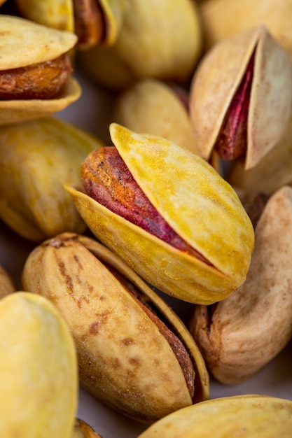 Side view of salted roasted pistachios on white background