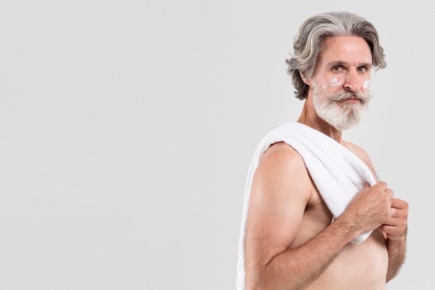 タオルでシャワー後の年配の男性の側面図