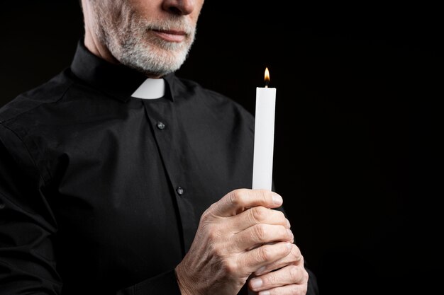 Side view senior man holding lit candle