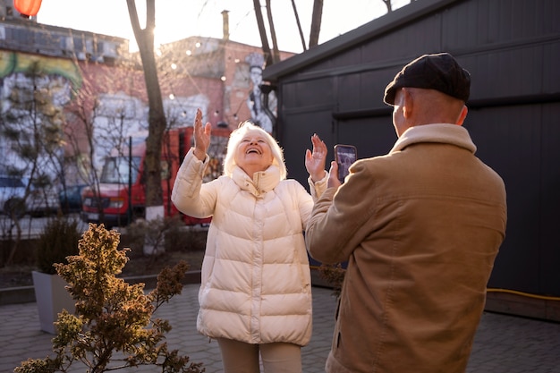 무료 사진 여자의 사진을 찍는 측면 보기 시니어 남자