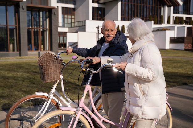 Free photo side view senior people with bicycles in park