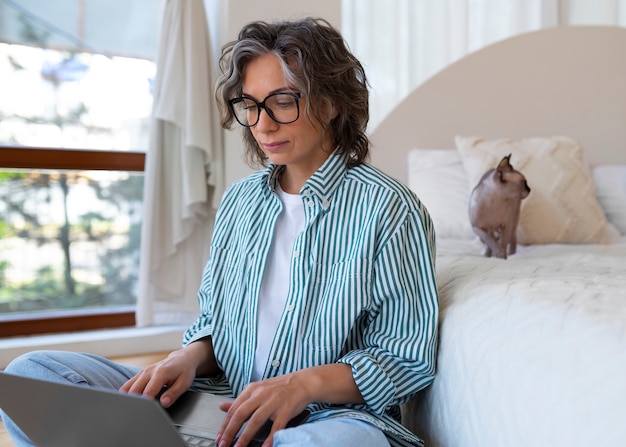 Free photo side view senior woman with cat at home