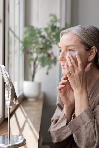 Free photo side view senior woman with eye patches