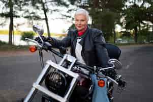 Free photo side view  senior woman with motorcycle