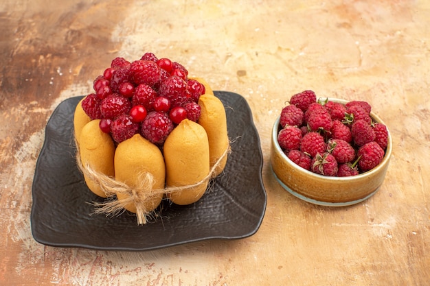 Free photo side view of set table with a gift cake and fruits for guests on mixed color table