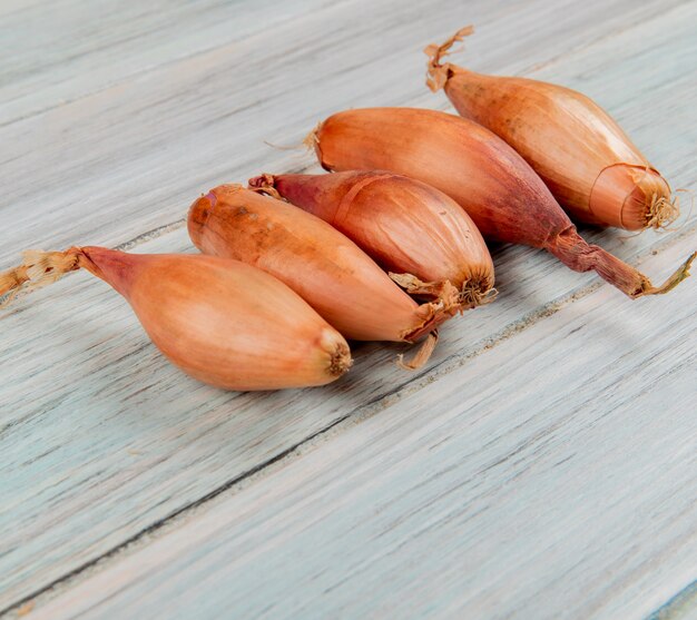 Side view of shallots on wooden background