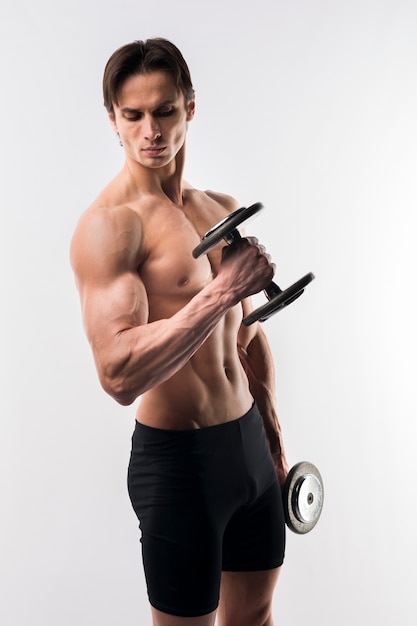 Side view of shirtless athletic man holding weights